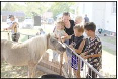 The Griffith family pets a pony in the Kids Zone petting zoo during Frontier Days in 2022. File photo
