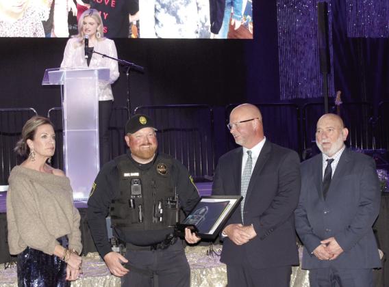 Sergeant Dennis Raines accepts the 2024 Officer of the Year Award from 2023 Officer of the Year Lt. Jason Crouch, third from left, during the 20th Annual “Celebration of Heroes” Shawnee Police Foundation Awards Banquet on Jan. 31. Raines responded to the scene of a stabbing where he applied compression gauze to two wounds until an ambulance arrived. Raines also received a Life Saving Award. Also shown are SPF Chair Melissa Stuteville, far left, and Deputy Chief John Goss. Abigail Ogle was the emcee.