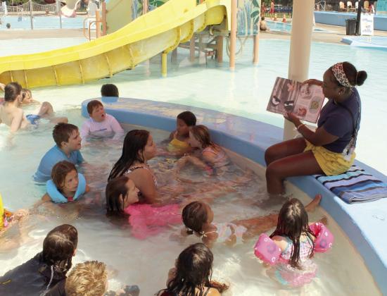 Shawnee Public Library Children's Librarian Destiny Temple reads "The Bad Seed" by Jory John at the "Story Break at the Splash Pad at Woodland Park" program on July 22. Temple also read "Mr. Fox's Game of No" by David LaRochelle during the 15-minute pool safety break. Visit https://pioneerlibrarysystem.org/ and click on Events to see upcoming programs.