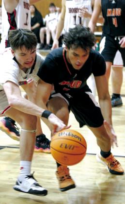 Maud junior Curtis Jordan tries to keep control of the ball as Macomb sophomore Radlee Blaine tries to steal it at the Macomb home game on Nov. 28. Maud won, 60-36.