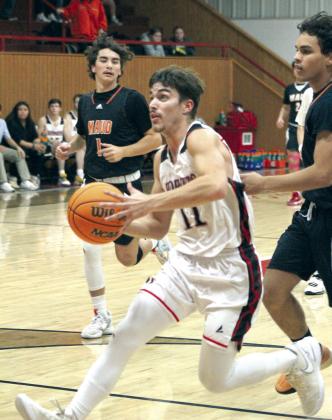 Macomb senior Cameron Richardson drives to the basket followed by Maud players Ryan Poull, left, and Curtis Jordan.