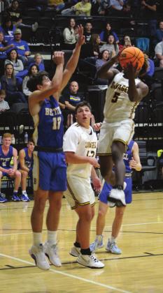 Tecumseh’s Daveon Mays makes a basket as Bethel’s John Gordon plays defense during the Tecumseh home game on Dec. 3. Bethel won 77-56. Countywide &amp;amp; Sun/Natasha Dunagan