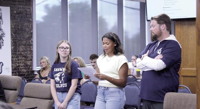 Shawnee Student Council member, senior Michale Young, speaks to the Shawnee Public Schools Board of Education about plans for one homecoming for the school year, which will include a dance and a parade, during the Aug. 10 meeting, as fellow senior and Stuco member, Kadence Jenkins, and Stuco Sponsor Ryan Boren look on. Natasha Dunagan, Countywide &amp;amp; Sun