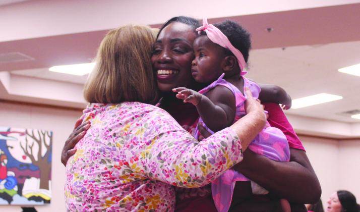 Tami Dorrell, the mother of Miss Oklahoma Tessa Dorrell, gets a hug from a former Choctaw High School student Marissa Lightsey, of Shawnee, and her seven-month-old baby, Imani Lightsey. Natasha Dunagan, Countywide &amp; Sun