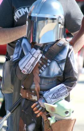 A young “Mandalorian” carries Grogu, more commonly known as Baby Yoda, in her satchel as she waits for the costume contest to begin at the Oct. 16 car show.