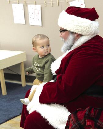 Seven-month-old Sutton Duarte, of OKC, looks worried as he sits on Santa’s lap at the Shawnee Pioneer Library on Nov. 17.