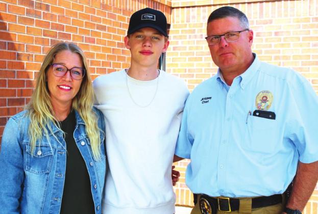 Landon Kidney, center, poses with his parents, Andrea and J.R. Landon has served as the Potawatomi Fire Team Photographer since their first game on March 4.