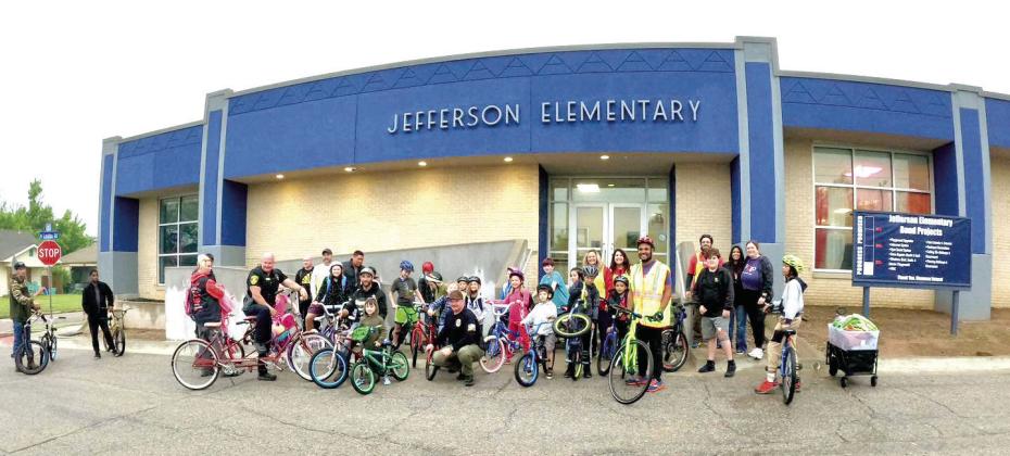 Pogo, Commissioner Odneal, and Jefferson students stand together outside the school after a successful ride to school on Bike to School Day. Photo provided