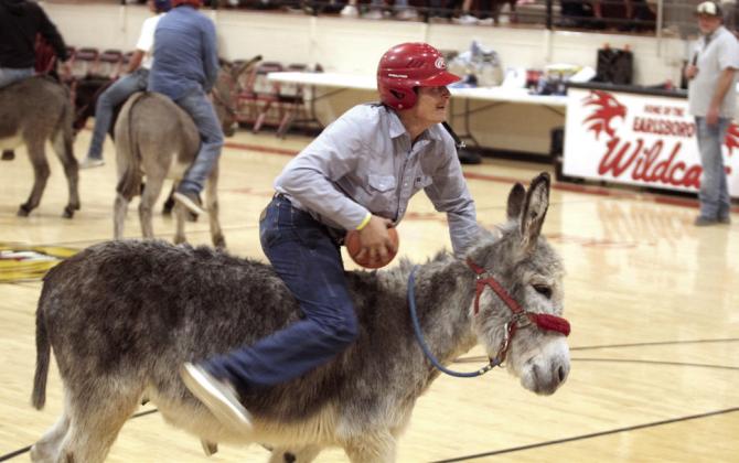 Earlsboro firefighter Cody Dailey tries to speed up his donkey on his way to the basket.