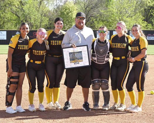 Before the April 7 home game against McLoud, Coach Perry Wilson was presented with a signed, framed photo commemorating his achievement of 400 coaching wins. Wilson is shown here with Tecumseh seniors, from left, Khabrei Simpson, Blakelee Parker, Tylee Brock, Maggie Wilson, Steeli Mitchell and Cadence Leba. Photo courtesy of Kenetta Lisenbee