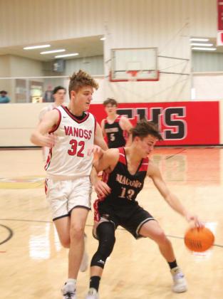 Macomb’s #13, Cameron Richardson, dodges Vanoss’ defenses before scoring a two-pointer at the first game of the Jim Walling Invitational Earlsboro.