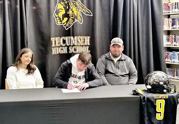 Tecumseh's Kaseon Pines signs a letter of intent to play football with Panhandle State University on Feb. 13, as his parents Tiffany and Jake Pines look on. Photo provided by Casi Bays.