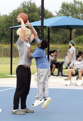 Elijah Winters, 10, of OKC, tries to block a pass by JJ McClain. McClain played football at North Rock Creek before accepting a scholarship to continue play at OBU this season.
