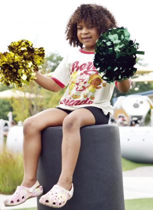 Alaya Harteld, 6, daughter of Taylor Yahola, plays with the OBU Cheerleader's poms during the OBU Fan Day at KidSpace Park on Aug. 30.