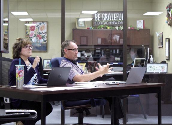 Minutes Clerk Denise Flowers listens as Bethel Public Schools Superintendent Dr. Matt Posey speaks to the Bethel Board of Education at their Aug. 14 meeting. Countywide &amp; Sun/Natasha Dunagan