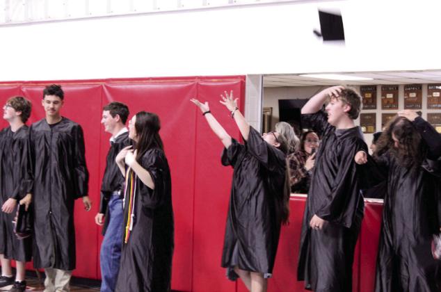 Macomb High School's 2026 graduates toss their caps at commencement on May 9 in the Macomb gym. Shown, from left, are Trevor Laughery, Blayze Lewis, Jason May, Kaylin Musshafen, Danelle Riley, Damien Sanders and Kamdyn Valkosak. Macomb graduated 24 seniors this year. Natasha Dunagan, Countywide &amp;amp; Sun