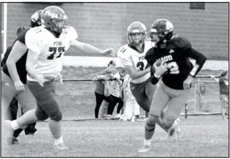 Maud freshman Evan Buxton runs the ball and avoids two Paoli Pugs in the first quarter of the Sept. 21 home game. This was a Class C District game, and the Tigers won, 20-8.