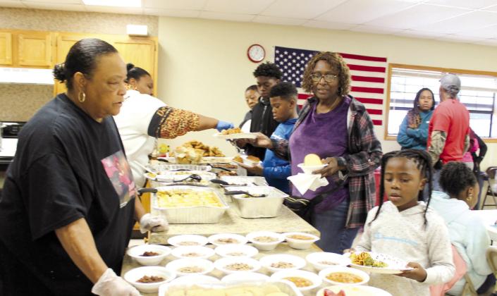 Frances Phillips, far left, offers Kaylee Counts, 6, a variety of foods in the potluck line, as Counts' grandmother Shirley Cooks looks on, during the Brooksville 120th Year Celebration held at the Brooksville Community Center on Oct. 14. Countywide &amp; Sun/Natasha Dunagan