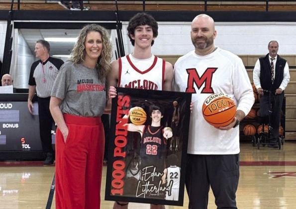 McLoud junior Edan Litherland poses with his parents, Stephanie and Eric Litherland, who are presenting him with his 1,000 Points banner and game ball on Feb. 6. The younger E. Litherland reached 1,001 high school career points during the Feb. 3 game at Tecumseh, where he contributed 34 points. The elder E. Litherland is McLoud's Head Boys Basketball Coach and Athletic Director and also celebrated his 200th win as a coach on Feb. 6. Natasha Dunagan, Countywide &amp;amp; Sun