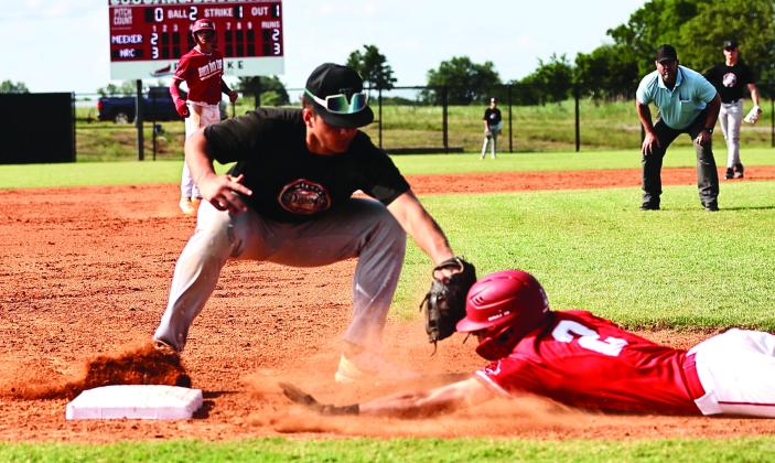 Meeker’s 3rd baseman gets the throw from the catcher to tag out North Rock Creek’s Owin Payne.