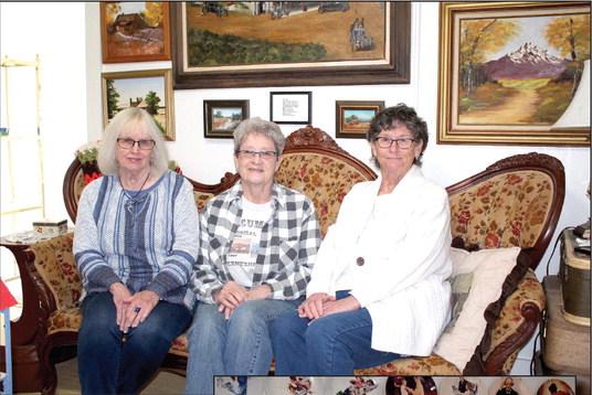 Tecumseh Historical Society Board Officers Arthenia Haney, Jane Fleming and Jan Parker pose on the Carters' Victorian couch at the Tecumseh museum. They and others have put in many hours of work on the museum buildings and curating donations, and they hope that more people will volunteer. Countywide &amp; Sun/Natasha Dunagan