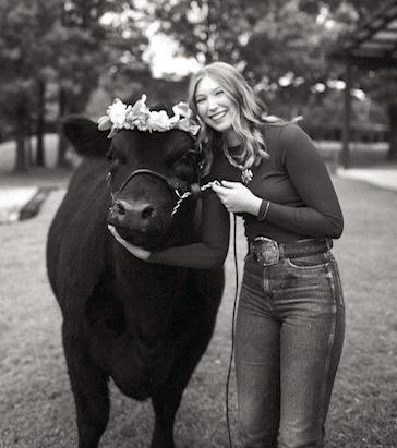 Eva Webb, of Shawnee, poses with one of her cows. Webb recently received her American FFA Degree. Photo provided.