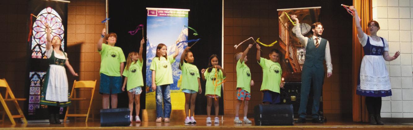 Above: Maddie Wall (Fraulein Maria), far right, sings "My Favorite Things" while instructing cast member Kristin Kuns (Liesl), Volunteer CPN Students (the youngest seven Von Trapps) and cast member Lucas Schrantz (Friedrich), how to twirl their ribbons