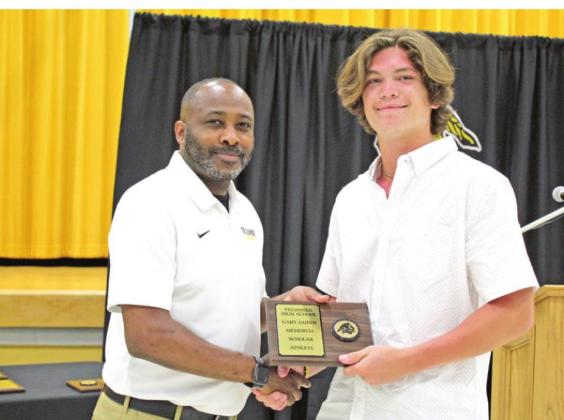 Coach Bryant Edwards presents the Gary Guinn Memorial Scholar Athlete Award to senior Jaxon Meyers.Meyers received the Jim Brown Memorial Sportsmanship Award from KIRC Radio, as well.