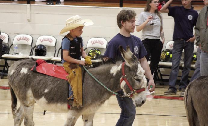 Dressed for the occasion, Rhette Rodgers gets a donkey ride, led by a fire fighter, during the Town of Earlsboro Donkey Basketball game on April 9. Children were given rides between the two games.