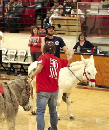 Earlsboro Volunteer Firefighter and EHS senior James Smith aims for the hoop over the defense during the Donkey Basketball game.