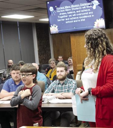Shawnee third-grader Ben Wilson recites and performs the motions to the Horace Mann Elementary Mission Statement, with the help of Principal Christi Lovelady, during the March 3 Shawnee Public Schools Board of Education meeting. Natasha Dunagan, Countywide &amp; Sun