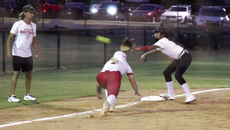 Earlsboro freshman EmmaLee Yesslith makes the catch and tags out McLoud's Avery Soward, as Soward dives back to third base and McLoud Head Coach Garrett Hannah watches, during the Aug. 24 game at McLoud. McLoud's Lady Redskins beat the Lady Wildcats, 4-0, and have a record of 17-2, so far. Photos by Natasha Dunagan, Countywide &amp;amp; Sun