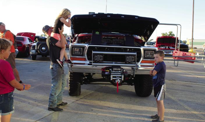 Brandon Smith, of Shawnee, holds up his daughter, Letti, 5, to see the engine of a 1979 Ford F150, owned by Mark Czywczynski of Seminole, as his son, Wesley, 8, looks on during the Frenzy on Federal Car Show on Oct. 1. There were 41 vehicles in the show this year.