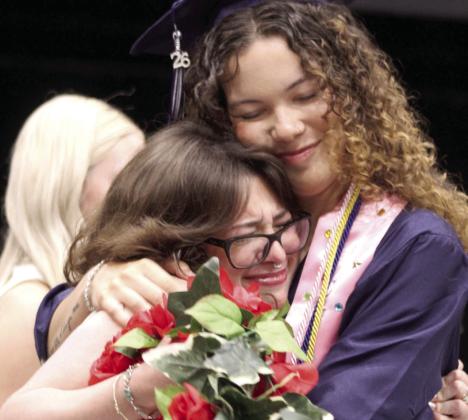 Grad Chaiyah Taylor and garland girl Chyanne Lowe share a hug after Taylor received her diploma at the Shawnee High School Graduation, held at FireLake Arena on May 17. Shawnee graduated 260 seniors.