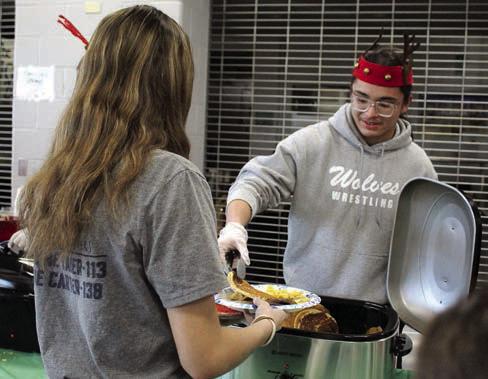 Jaxon Shawnee serves pancakes to Bella Tipton during Breakfast with Santa.