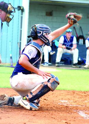 Asher sophomore Mitchell Skender snatches the ball from above as catcher during the third inning of the Aug. 25 home game.