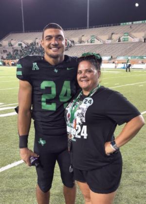 North Rock Creek Alum, Caleb Hawkins poses on the sidelines of the University of North Texas with his mom, Krista Hawkins. Photo Provided