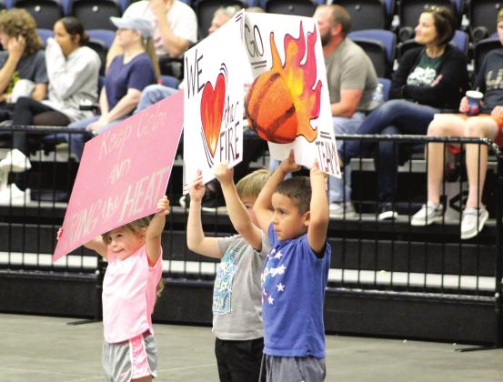 Preslee Robinson, 4, Daxton Robinson, 6, both of Wewoka, and Jaxon Estala, 4, of Shawnee, hold up signs to encourage the Potawatomi Fire during their first Second-Round Playoff game against the Shreveport Mavericks at FireLake Arena on June 8.