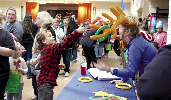 Ryatt Loudermilk, 7, of Tecumseh, plays reindeer ring toss with Tecumseh First United Bank Community President Jill Spencer during the Grinchmas Whoville event, held in the Tecumseh City Hall Auditorium on Nov. 30. Countywide &amp; Sun/Natasha Dunagan