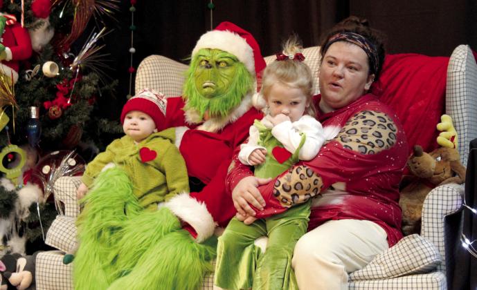 The Grinch poses with Cade Glasgow, six months; Karsin Glasgow, 2; and Ashley Glasgow, all of Tecumseh, during the Grinchmas Whoville event, held in the Tecumseh City Hall Auditorium on Nov. 30. The Tecumseh Pioneer Library took and printed out 320 pictures this year.