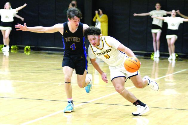 Guarded by Bethel senior Roger Brooks, Tecumseh senior Aveon Stokes takes the ball upcourt before making a basket during the Feb. 7 homecoming game at Tecumseh. The Savages won a hard-fought game, 54-49, in overtime. Countywide &amp; Sun/Natasha Dunagan