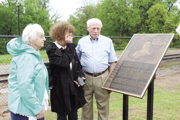 Former Vietnam POW Danny Glenn, originally of Shawnee, and his sisters, Kay and Jane, look over a bronze plaque which was dedicated to him at the Paul and Ann Milburn Center on May 4. His fellow 1957 Shawnee graduate, Walter Coffey started the ball rolling on the plaque six years ago. Countywide &amp; Sun/Natasha Dunagan
