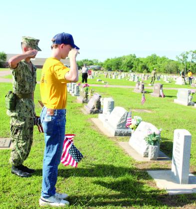 U.S. Naval Sea Cadets SN Zachary Hastings and Recruit Nikki Everhart salute the grave of Navy veteran Terry Peltier on May 17 at the Tecumseh Cemetery. Natasha Dunagan, Countywide &amp; Sun