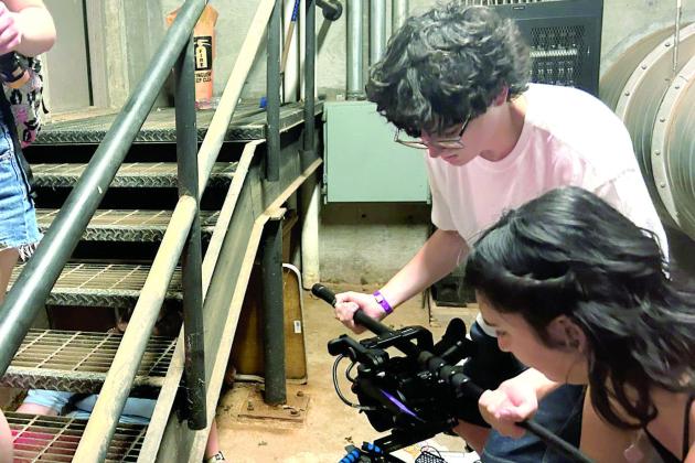 NIcholas Kosemund is shown here using a boom mic to slide his cinema camera in this action shot for his Oklahoma Art Institute film short over the summer. Photo Provided.