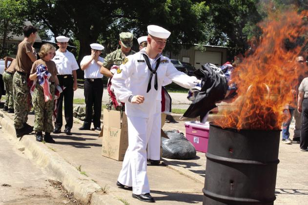 US Naval Sea Cadets Corp. SA Gabriel Synakowski, in the Patriot Division, retires a flag to the flames.