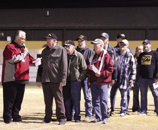 At least 30 veterans participated in the "veteran's parade" where they were announced by Tecumseh High School Assistant Band Director Bailey Vaughn, shown left, and stood on the THS football field to listen to their service theme songs. This was part of the Veteran's Day Light Show, coordinated by Band Director John Outon, who also invited the Meeker and North Rock Creek High School bands this year.