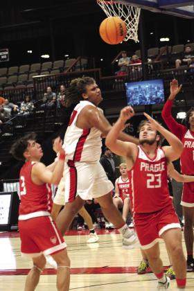 McLoud senior Tryce Lewis tries for a basket but is met with several Prague defenders during the first quarter of the game.