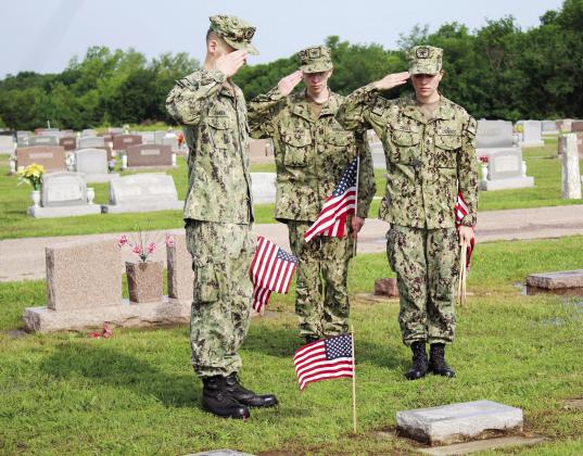 Petty Officer Third Class Lukasz Baker, Seaman Recruit Kenneth Irwin, and Chief Petty Officer Anna O’Dell salute a flag placed on a veteran’s grave at Tecumseh Cemetery on May 20. There are approximately 1,200 veterans’ graves at the cemetery, which were decorated in preparation for Memorial Day by the U.S. Naval Sea Cadets and Training Ship Oklahoma members, according to Sea Cadets Regional Director Donna Snodgrass. Countywide &amp;amp; Sun/Natasha Dunagan