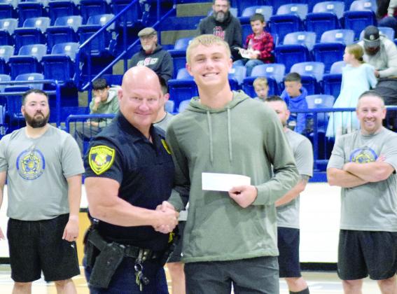 Shawnee High School Resource Officer, Corporal Shawn Parsons, presented a 2025 Freeland Wood Scholarship in the amount of $1000 to Shawnee High School Student, Camden Sateran during half time of the Shawnee Fraternal Order of Police Charity Basketball Game on April 19th. Julie Talton, Countywide &amp; Sun