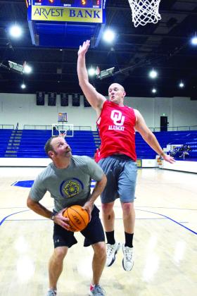 Shawnee Officer Nick Auld looks for the basket around OU Alum, Austin English in the charity game held at the PAAC on April 19th. Julie Talton, Countywide &amp; Sun